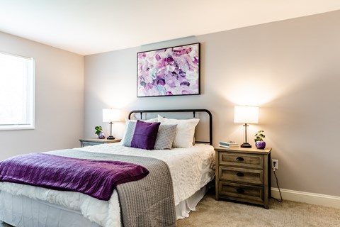 a bedroom with a bed and two night stands with lamps